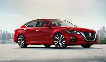 2023 Nissan Altima in red with city in background illustrating last year's 2022 model in Nissan of Visalia in Visalia CA